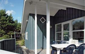 Bjerregårdにある3 Bedroom Lovely Home In Hvide Sandeのデッキにテーブルと椅子が備わる家