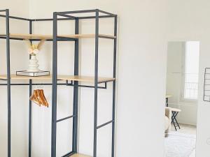 een zwarte boekenplank in de woonkamer bij Charmant studio calme, proche La Défense & Paris in La Garenne-Colombes