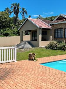 a house with a swimming pool in front of a house at 373 on Bristol Home in Port Edward