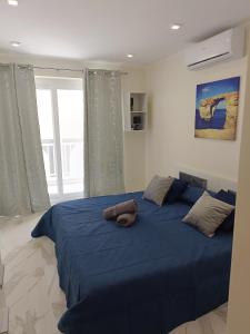 a bedroom with a large bed with blue sheets at 54 ONE by RW San Julian's in St Julian's