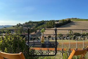 a table with a vase on top of a iron fence at [Appartamento con vista] Finestra sulle colline in Fermo