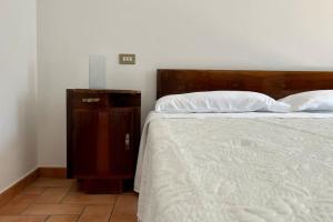 a bed with a wooden headboard next to a wooden cabinet at [Appartamento con vista] Finestra sulle colline in Fermo
