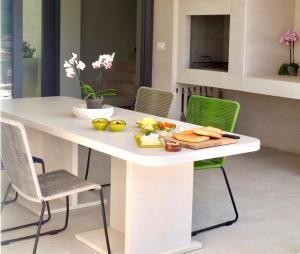 une table blanche avec une plaque de nourriture dans l'établissement The White House, Brac, à Pučišća