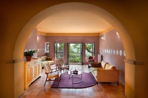 an archway in a living room with a couch and chairs at La Pensione di Vignamaggio in Panzano