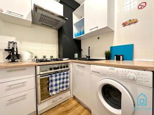 a kitchen with a washer and a washing machine at Colourful Room in Gdańsk