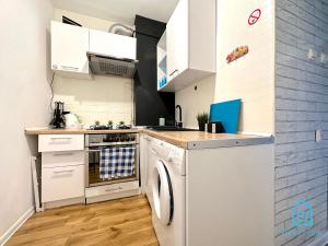 a kitchen with a stove and a dishwasher at Colourful Room in Gdańsk