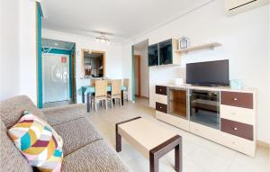 uma sala de estar com um sofá, uma televisão e uma mesa em Awesome Apartment In Oropesa Del Mar With Swimming Pool em Oropesa del Mar