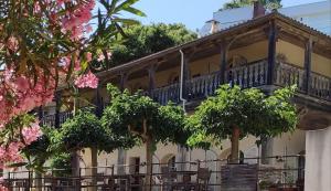 een gebouw met een balkon en bomen ervoor bij Le Clos des Sept Palmiers in Cavalaire-sur-Mer