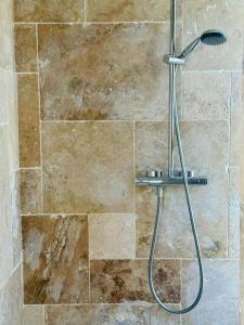 a shower in a bathroom with a stone wall at Le Cocon Parisien in Paris