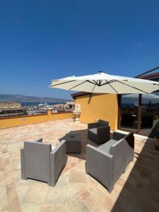 zwei Stühle und ein Sonnenschirm auf einer Terrasse in der Unterkunft THE DREAM in Villa San Giovanni