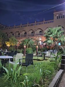 a courtyard with tables and chairs at night at Kasbah of Peace Draa Valley in Zagora