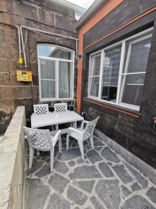- une table et des chaises blanches sur la terrasse dans l'établissement Hotel Elen, à Gyumri