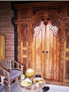 a room with a wooden door and a table with food on it at Nano Ari Homestay in Ubud