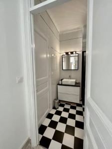 a bathroom with a black and white checkered floor at 2 pièces cocooning près du port/gare riquier in Nice