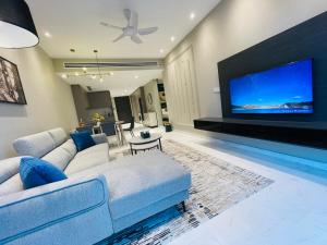 - un salon avec un canapé et une grande télévision dans l'établissement Eaton residences KLCC m@h, à Kuala Lumpur