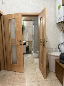 a bathroom with wooden doors and a sink and a tub at Flamingo House in Reghin