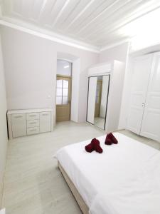 Dormitorio blanco con cama blanca y espejo en Hotel Elen en Gyumri