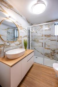 een badkamer met een wastafel en een spiegel bij Anna Suites in Kos-stad
