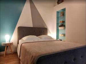 Un dormitorio con una cama grande con una pared puntiaguda en Bungalow les Songes, en Étang-Salé