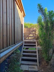 Un escalier en bois mène à un bâtiment en bois. dans l'établissement Bungalow les Songes, à L'Étang-Salé