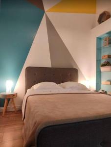a bedroom with a bed with a geometric wall at Bungalow les Songes in Étang-Salé