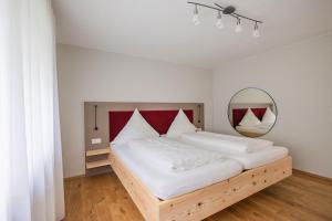 a bedroom with a large bed with a mirror at SEEZEIT Residence in Hagnau