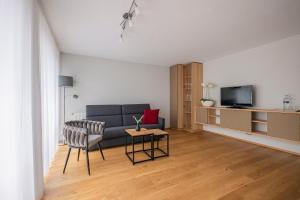 ein Wohnzimmer mit einem Sofa und einem TV in der Unterkunft SEEZEIT Residence in Hagnau