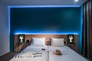 a bedroom with a bed with a blue wall at Infinity Blue Boutique Hotel & Spa - Adults Only in Hersonissos