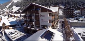 ariale Aussicht auf ein Hotel im Schnee in der Unterkunft Hôtel Macchi Restaurant & Spa in Châtel