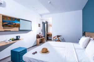 una camera d'albergo con un letto con un cappello sopra di Infinity Blue Boutique Hotel & Spa - Adults Only a Hersonissos