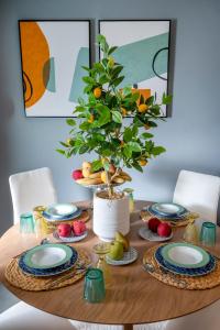 un tavolo con piatti e un albero in vaso di Anna Suites a Città di Kos