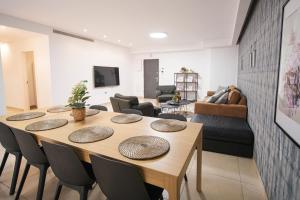 sala de estar con mesa de madera y sillas en Harav Kuk Modern Apartment By Nimizz, en Jerusalén