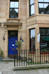 un edificio con una puerta azul y una valla en Argyle Backpackers, en Edimburgo