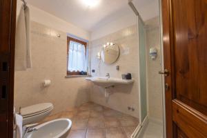 a bathroom with a sink and a toilet and a mirror at Le Rêve in Courmayeur