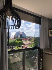 a room with a window with a view of a city at Garvey Hotel - Flat centro de Brasília in Brasilia