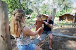 un hombre y una mujer jugando con una niña en Familie vakantiepark Krieghuusbelten en Raalte