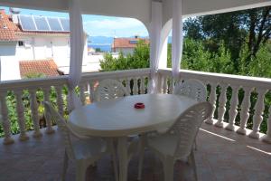 un tavolo bianco e sedie su un balcone di Apartments Monja & Dadi, Malinska, Vantačići a Vantačići