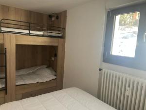 a bedroom with a bunk bed and a window at Très bel appart avec vue 8 personnes Alpe d’Huez in LʼHuez