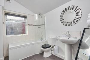 bagno bianco con lavabo, servizi igienici e specchio di Stylish Comfortable Home With Parking a Redcar Altre 18 foto
