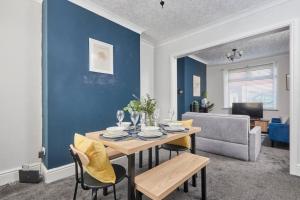 una sala da pranzo con tavolo e parete blu di Stylish Comfortable Home With Parking a Redcar