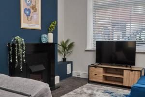 a living room with a flat screen tv on a entertainment center at Stylish Comfortable Home With Parking in Redcar