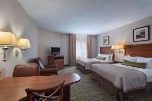 a hotel room with two beds and a table at Candlewood Suites Austin North-Cedar Park, an IHG Hotel in Cedar Park