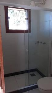 a bathroom with a shower with a toilet and a window at Suíte Delicada Centro Búzios in Búzios