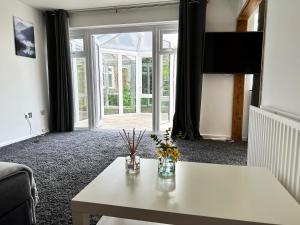 a living room with a white table and a window at Detached house in Essex in Harlow