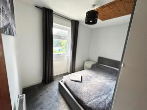 een kleine slaapkamer met een bed en een raam bij Detached house in Essex in Harlow