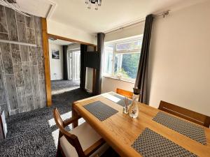 a dining room with a wooden table and a window at Detached house in Essex in Harlow