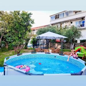 Ein kleines Mädchen spielt im Schwimmbad in der Unterkunft Apartments Ardoni in Ulcinj