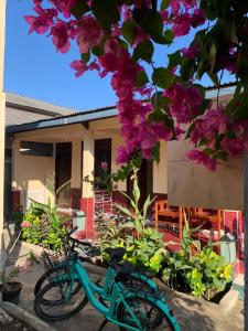 Una bicicleta azul estacionada frente a una casa con flores en Lisa Homestay, en Gili Trawangan