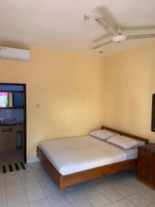 a bedroom with a large bed with a ceiling at Lisa Homestay in Gili Trawangan
