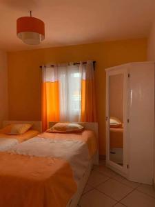 a bedroom with two beds and a window at Appartements Andrian Location in Antananarivo